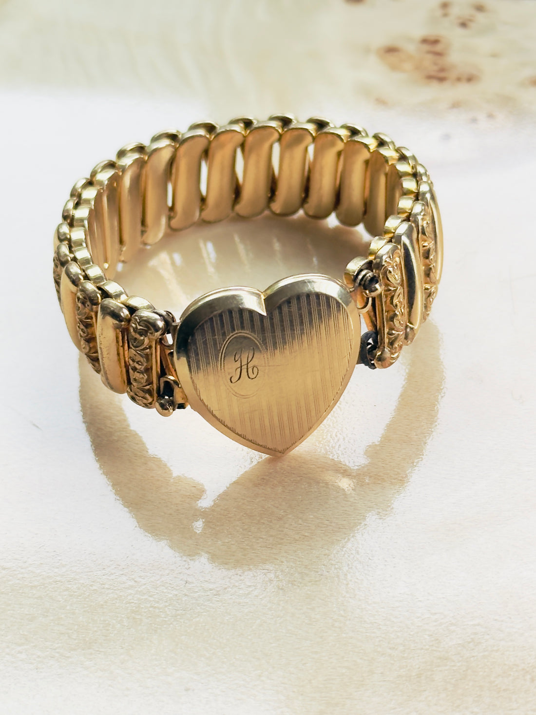 Layerable vintage gold statement bracelet with heart locket and engraved monogram, wide ornate expansion band, modern vintage jewelry