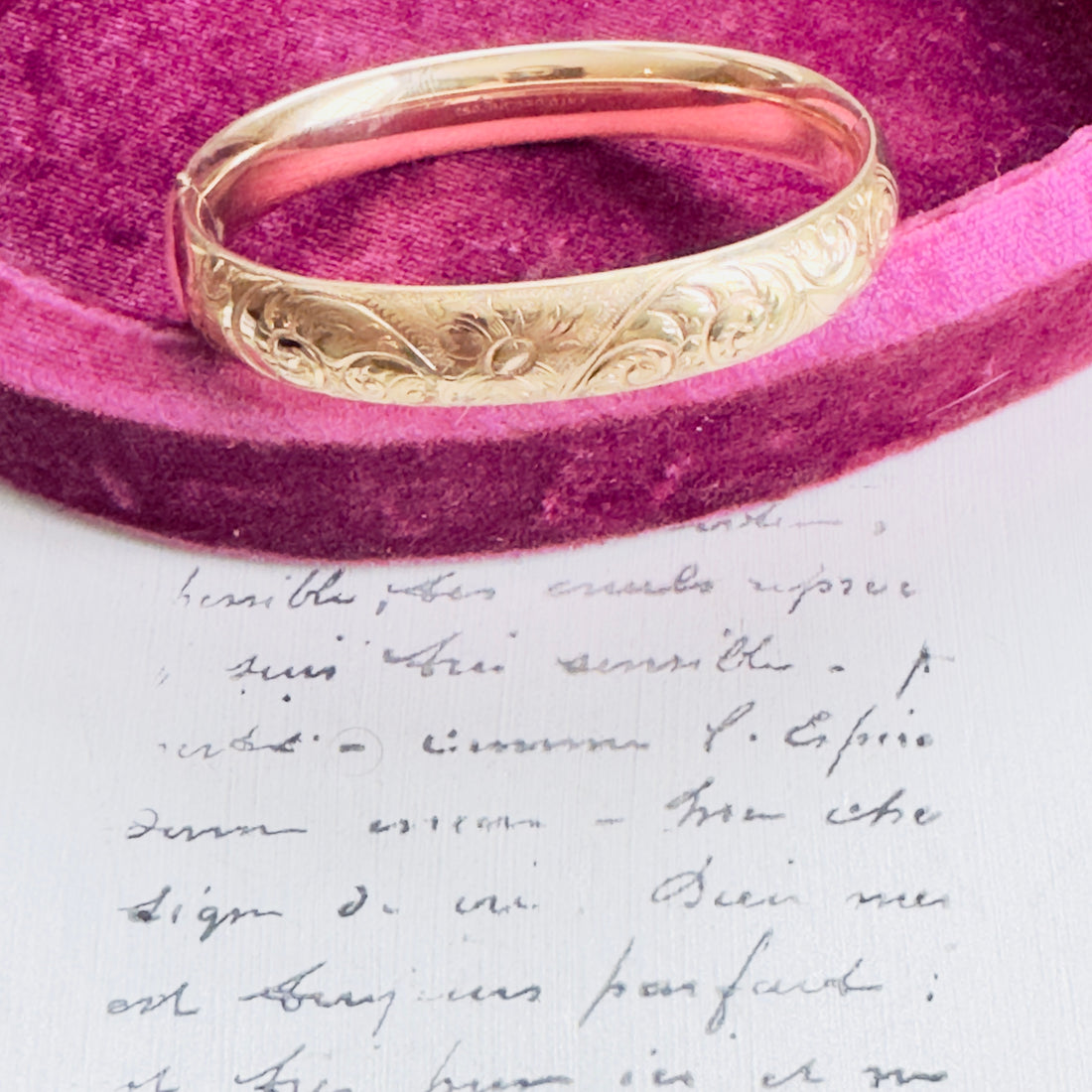 Close-up of floral etched design on antique gold bangle.