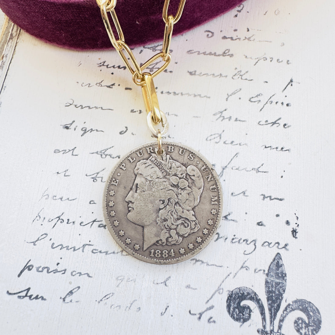 Morgan coin necklace styled flat with paperclip chain