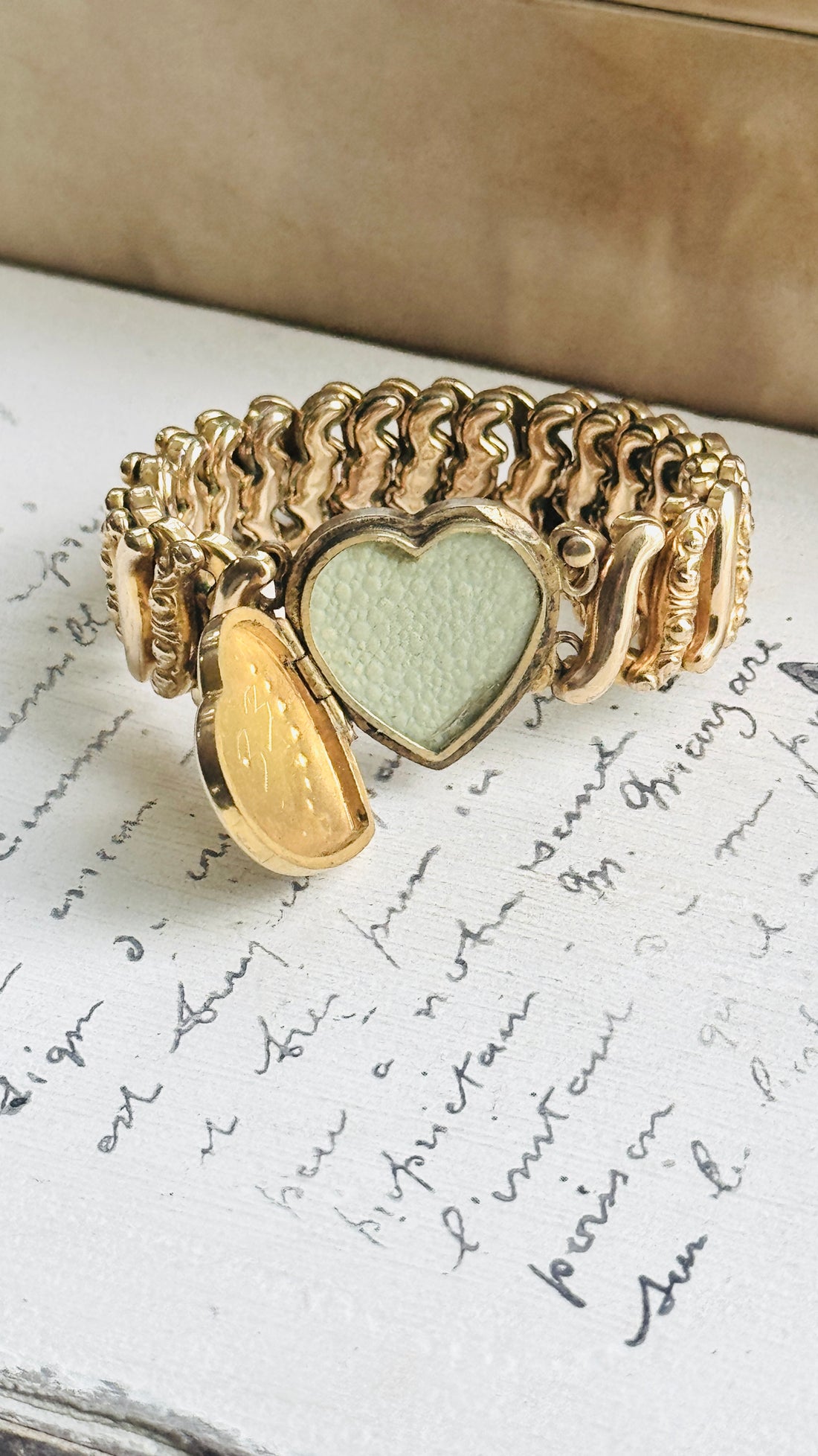 Open heart locket on vintage Carmen sweetheart expansion bracelet showing the original interior photograph frame