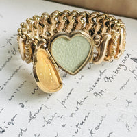 Open heart locket on vintage Carmen sweetheart expansion bracelet showing the original interior photograph frame