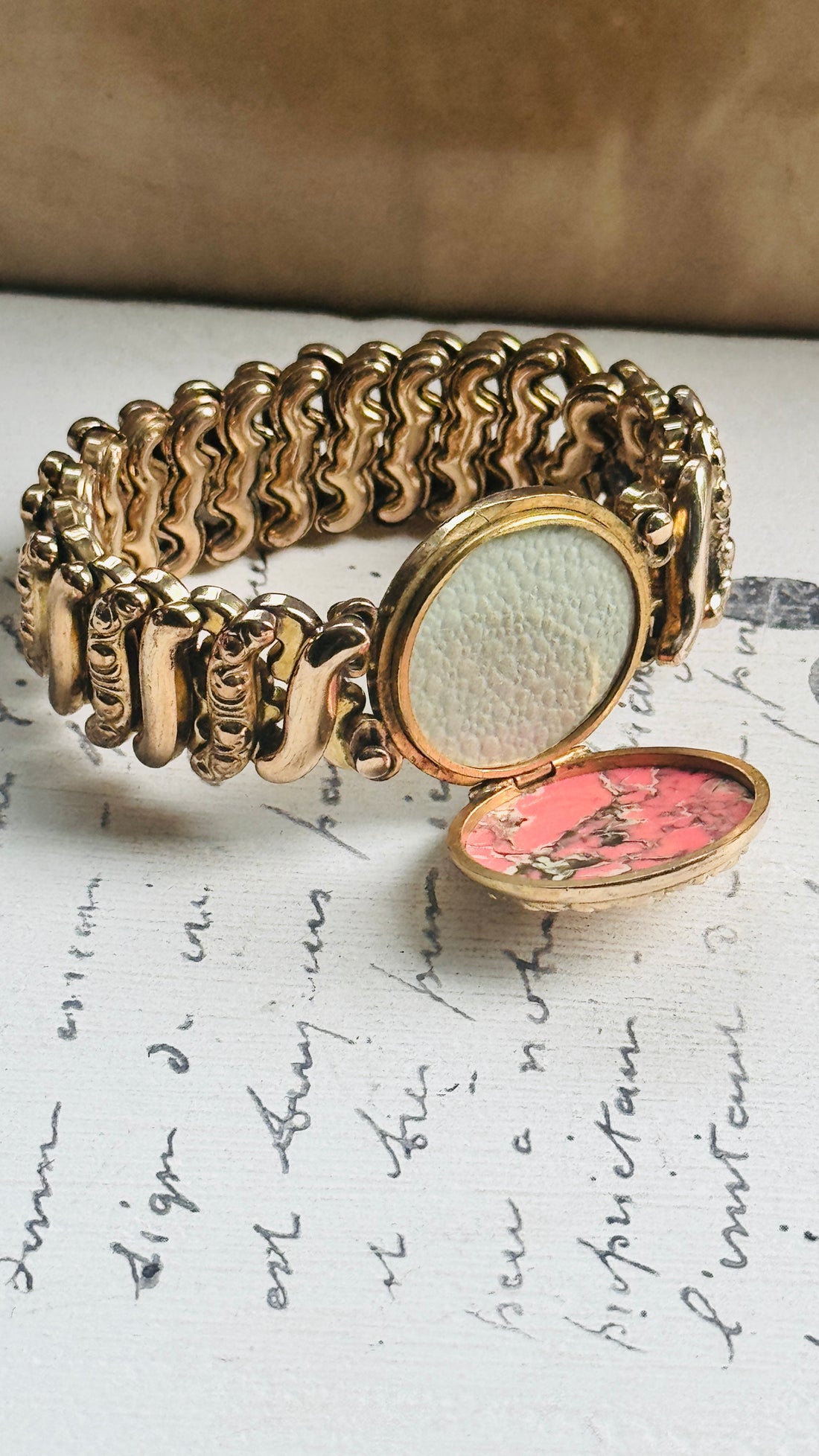 Original Carmen sweetheart bracelet with center locket opened to reveal space for two photographs or small mementos.