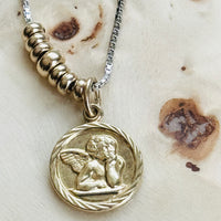 Original Victorian cherub pendant in 14k gold featuring the iconic pensive angel motif inspired by Raphael's Sistine Madonna.