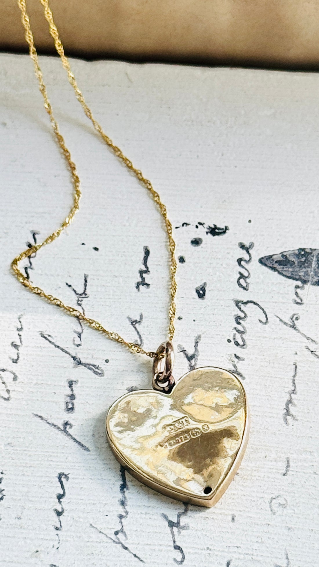 Reverse of antique English 9ct gold heart pendant showing Birmingham hallmarks and maker's mark.
