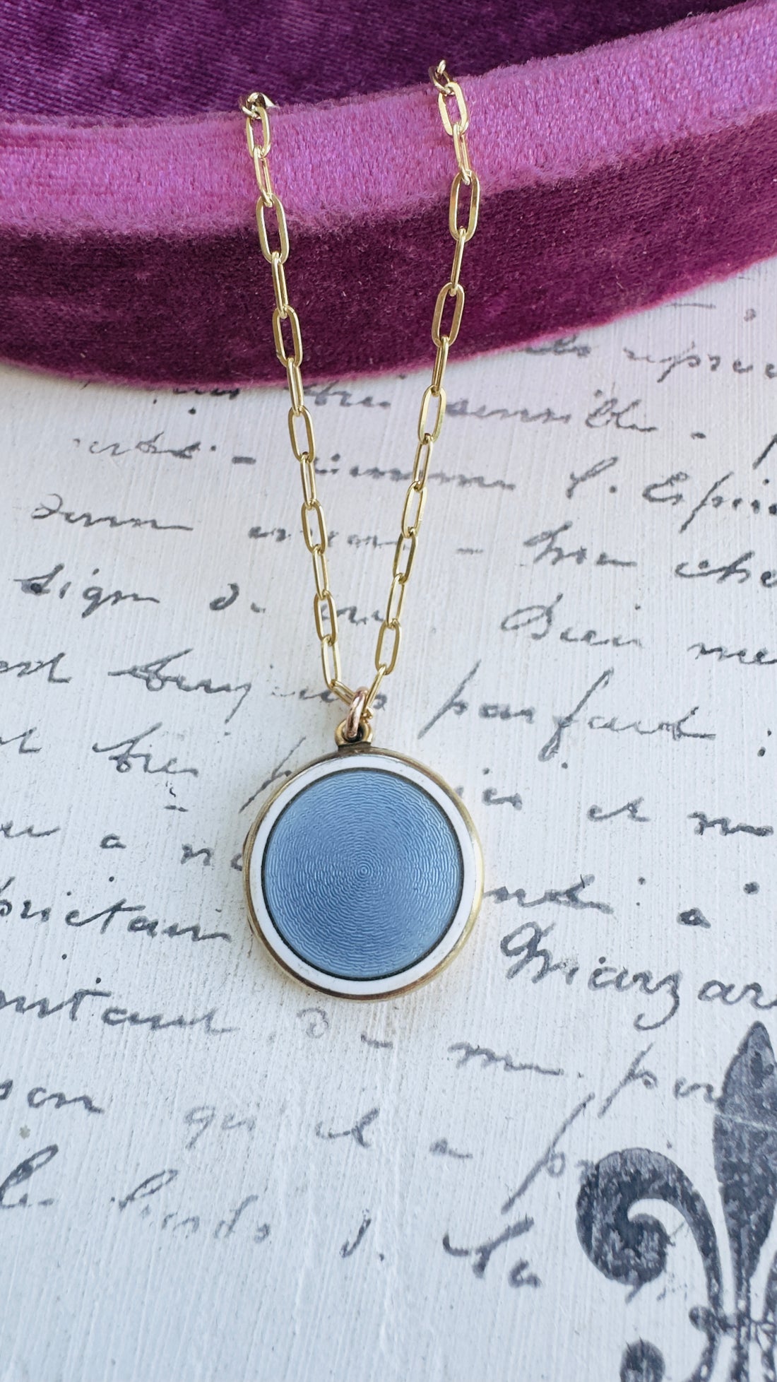 Round enamel locket with blue center and white border, gold frame