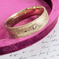 Close-up of engraved floral detail showing Taille d’Épargne enamel technique.

