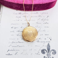 Close-up of engraved scroll and heart detailing on vintage locket