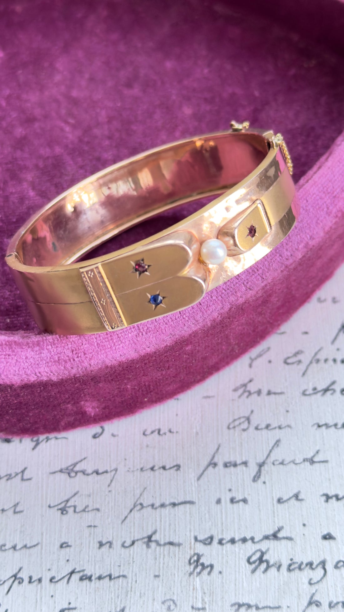 Victorian 14k gold hinged bangle with pearl center and red and blue starburst accents