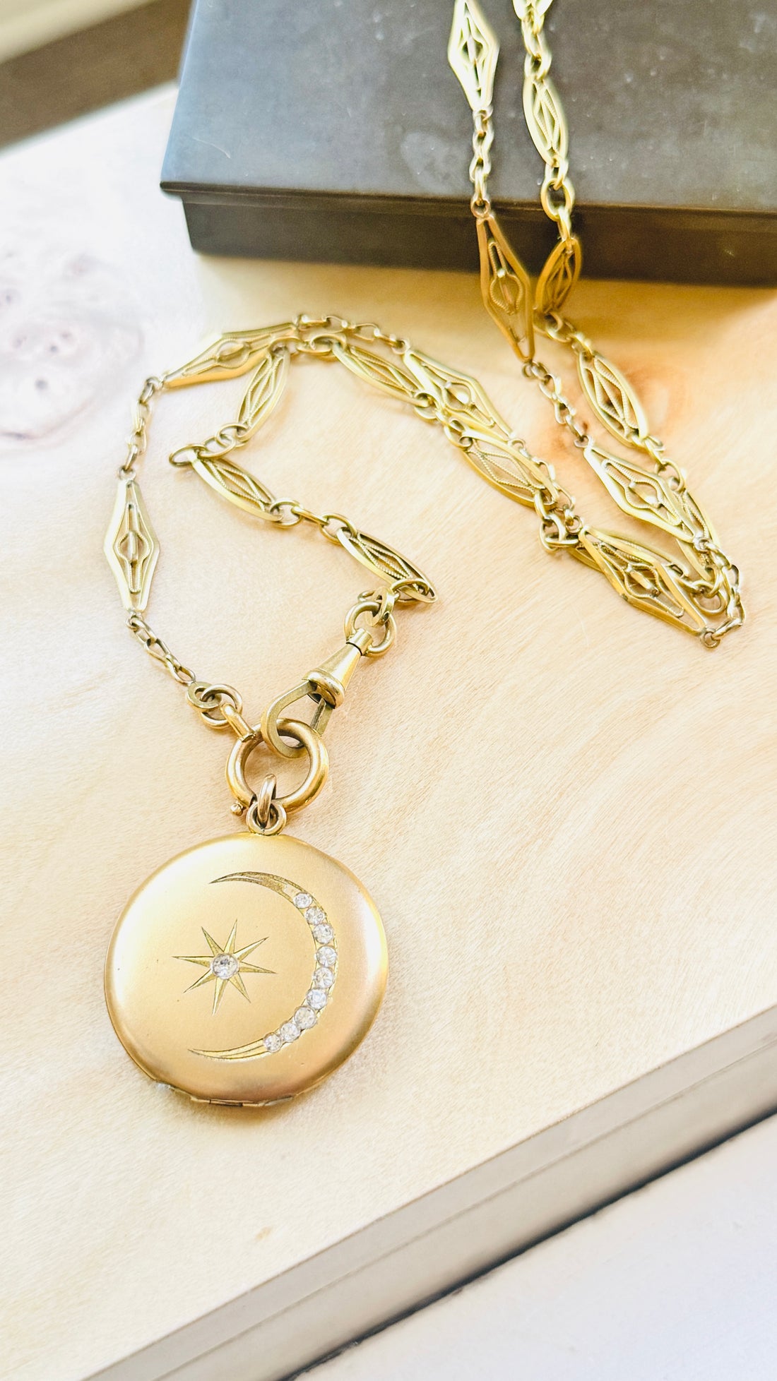 Victorian gold-filled crescent moon locket suspended from an antique French ORIA watch chain, full necklace view.