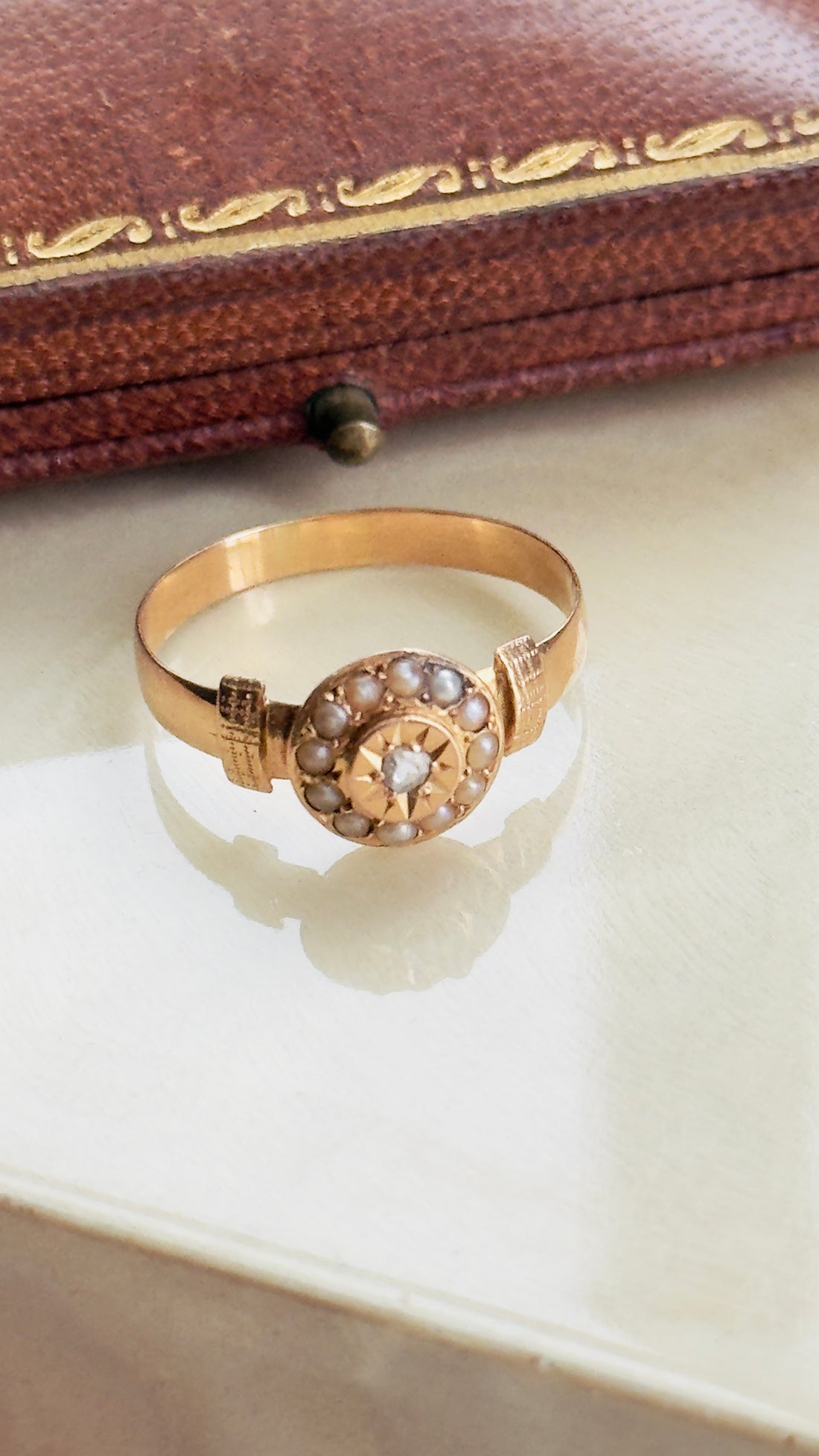 Victorian rose gold ring with rose-cut diamond and seed pearl halo circa 1890

