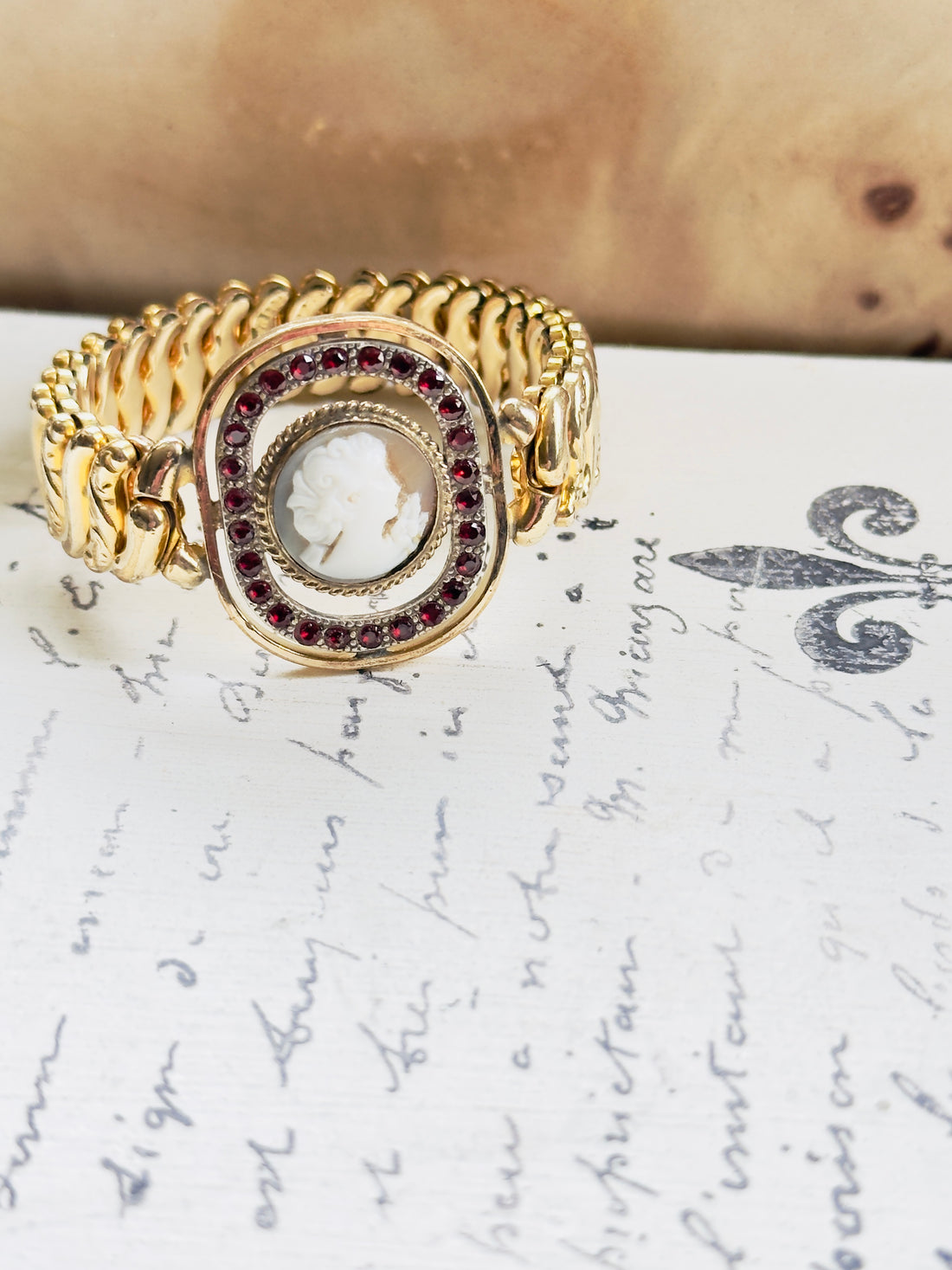 Vintage American Queen bracelet featuring cameo center with red stone accents

