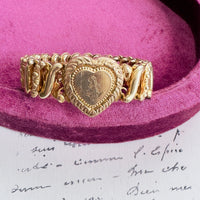 Close-up of engraved heart locket with raised detailing on vintage bracelet