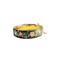 Vintage black and gold damascene-style hinged bangle bracelet with floral and bird motif