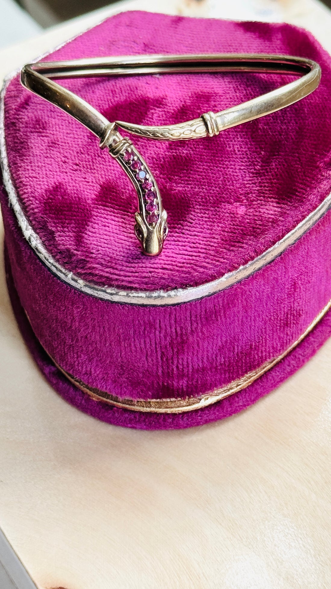 Vintage ruby snake bracelet displayed on a velvet antique ring box, highlighting the sculpted serpent head and natural ruby accents.