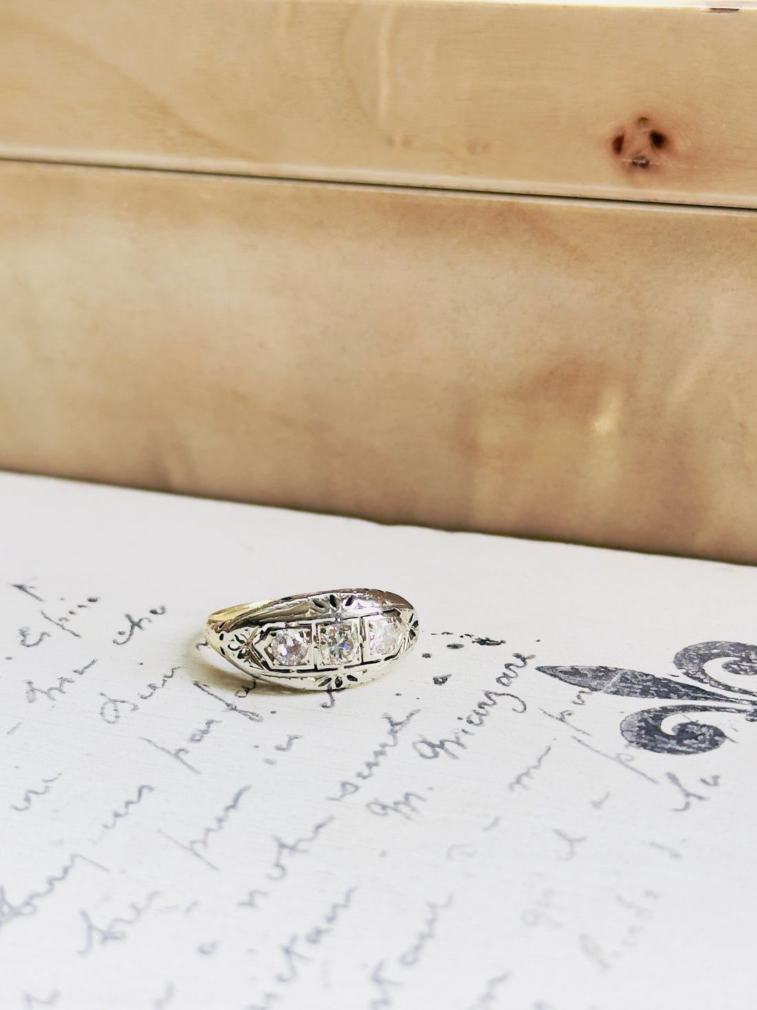 Vintage three-diamond ring with white gold bezels and yellow gold band