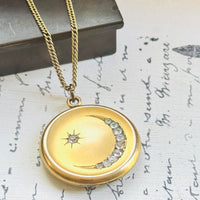 Antique gold filled crescent moon locket with paste stones and star, styled on vintage script paper