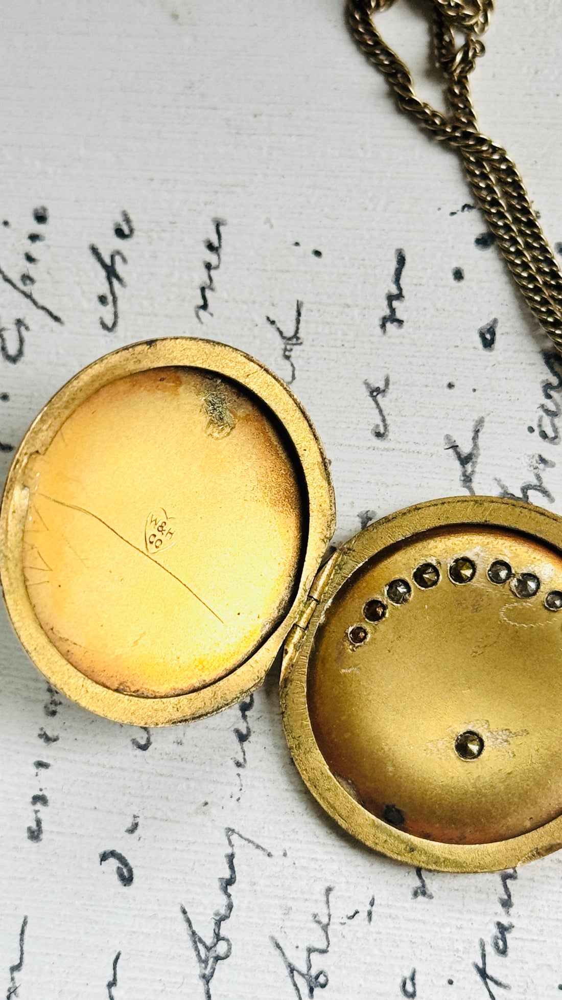 Antique gold filled crescent moon and star locket necklace with paste stones on a white background
