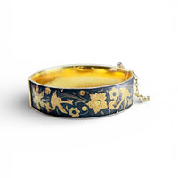 black and gold damascene-style hinged bangle bracelet with floral and bird motif