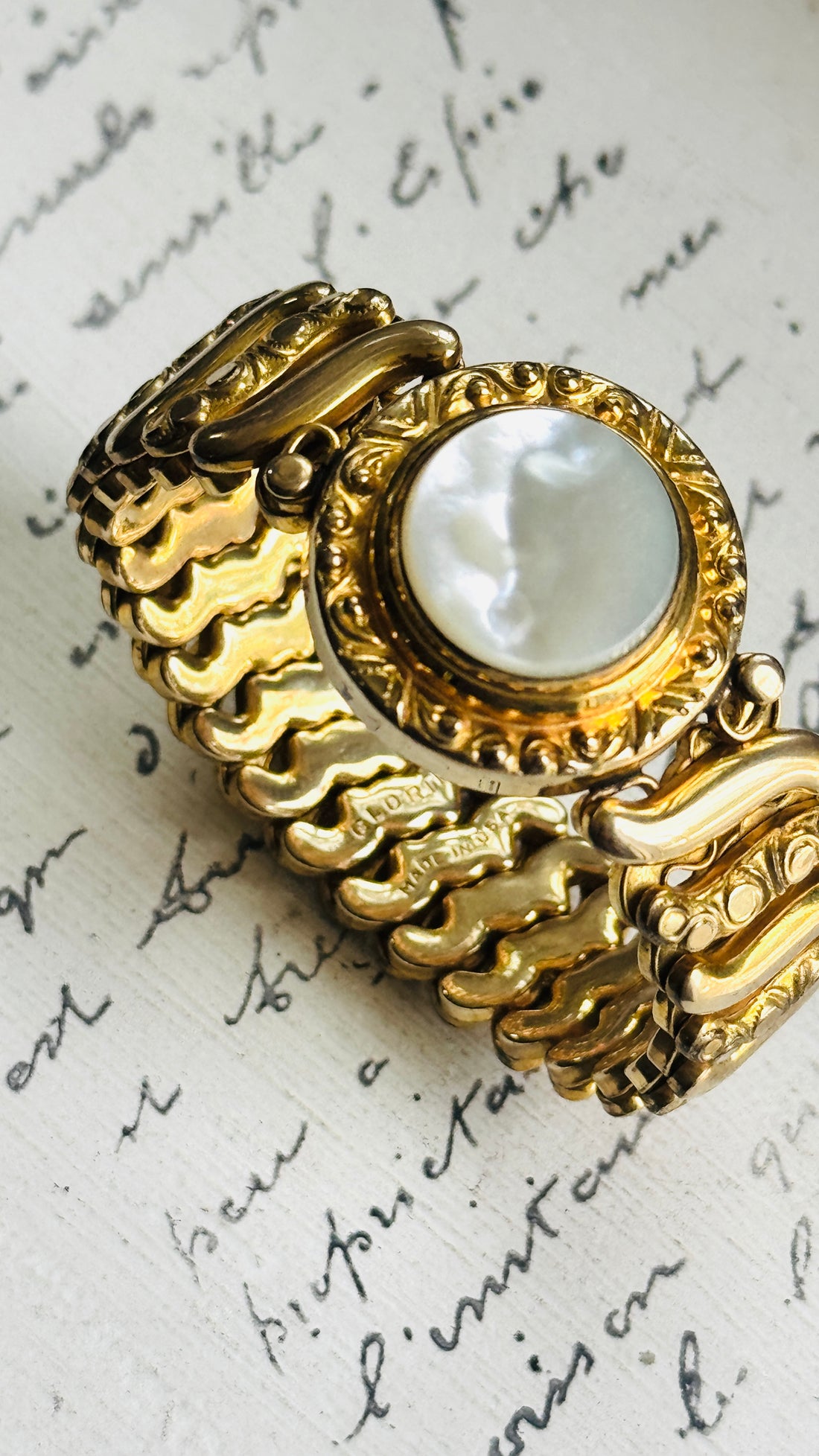 Close-up of the white Lucite center and engraved gold filled frame on a vintage Gloria sweetheart bracelet
