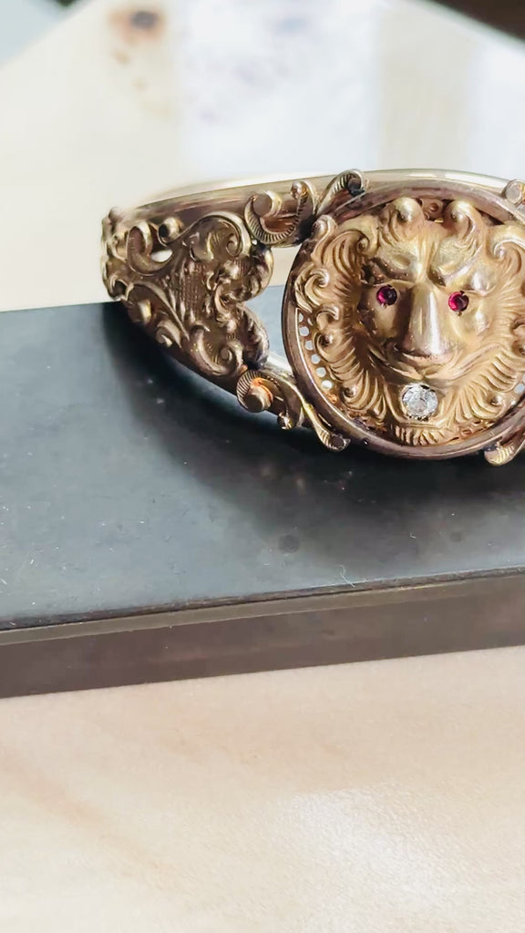 Video of Edwardian gold filled lion head hinged bangle bracelet showing the lion's red paste eyes and engraved scroll details