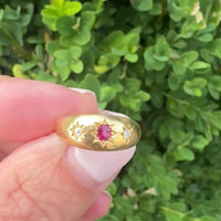 Close-up of Victorian 18k gold ring with ruby center stone and diamond accents, star-set flush in domed polished band, size 6