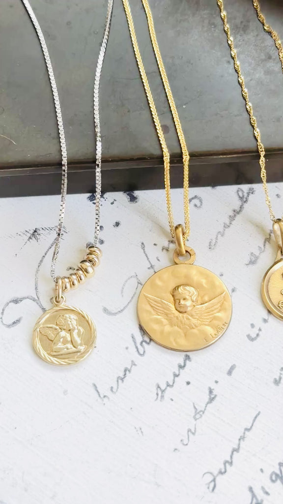 Video featuring a curated collection of antique French pendants, including a Victorian 14k gold cherub pendant alongside two petite French gold pendants.