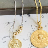 Video showing the antique FIX cherub medal, gold chain, scale, movement, and front and reverse details.