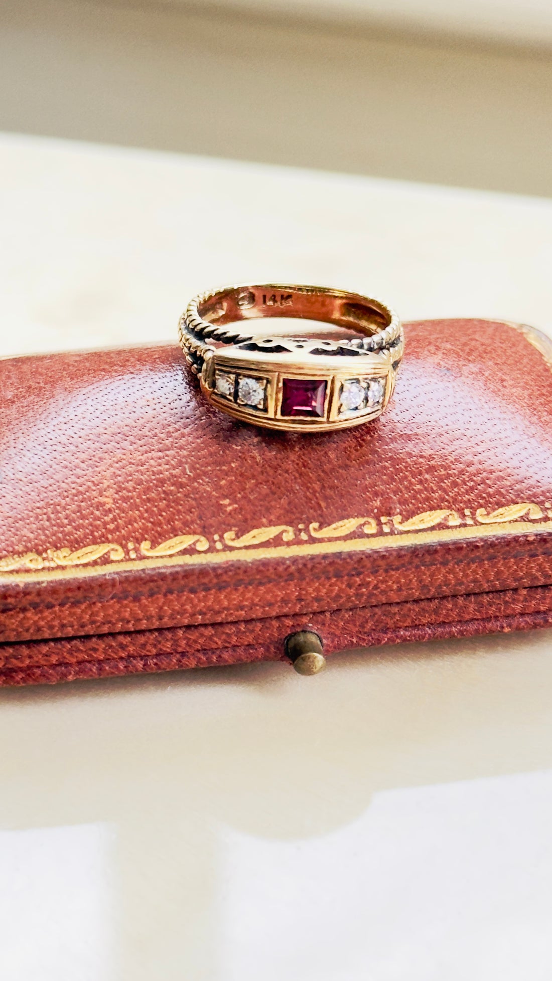 ruby ring with crown motif and rope twist shoulders