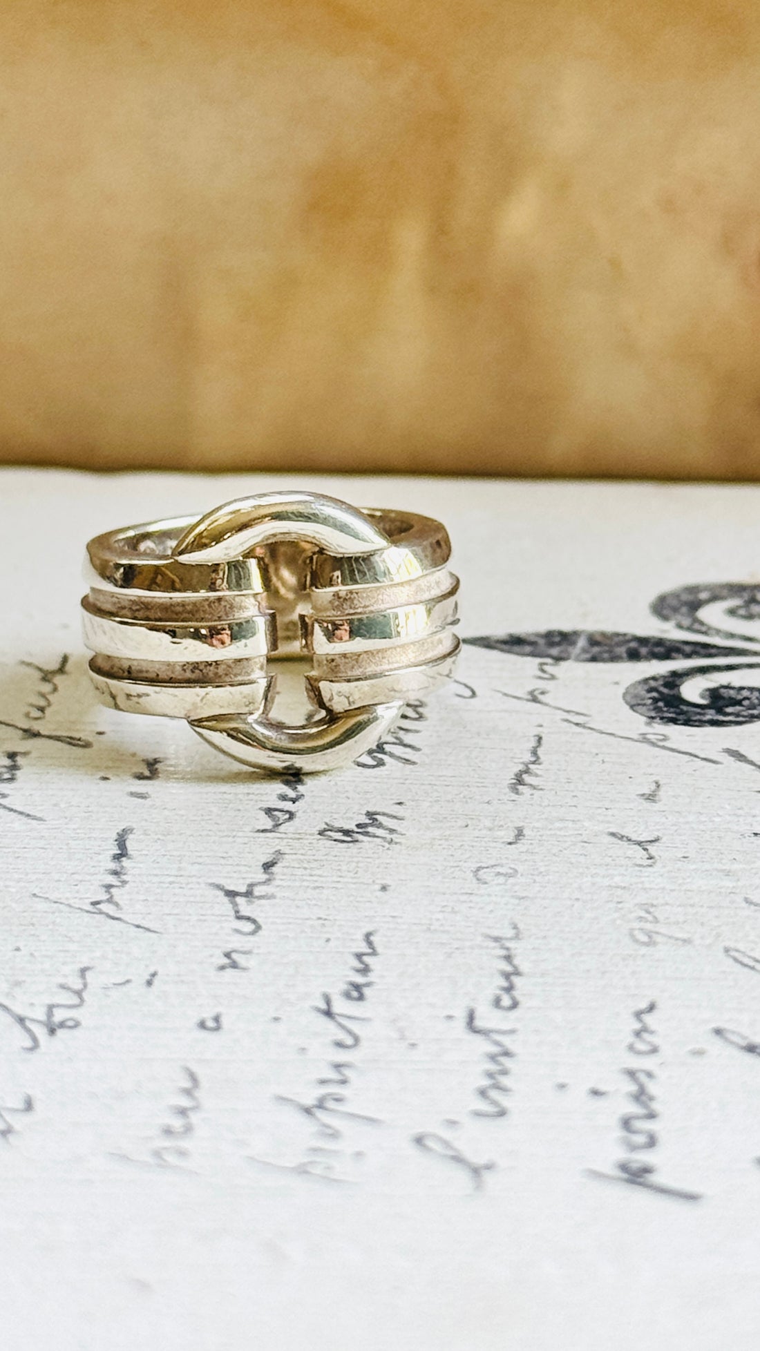 Front view of the Tiffany Atlas sterling silver ring styled on vintage script paper