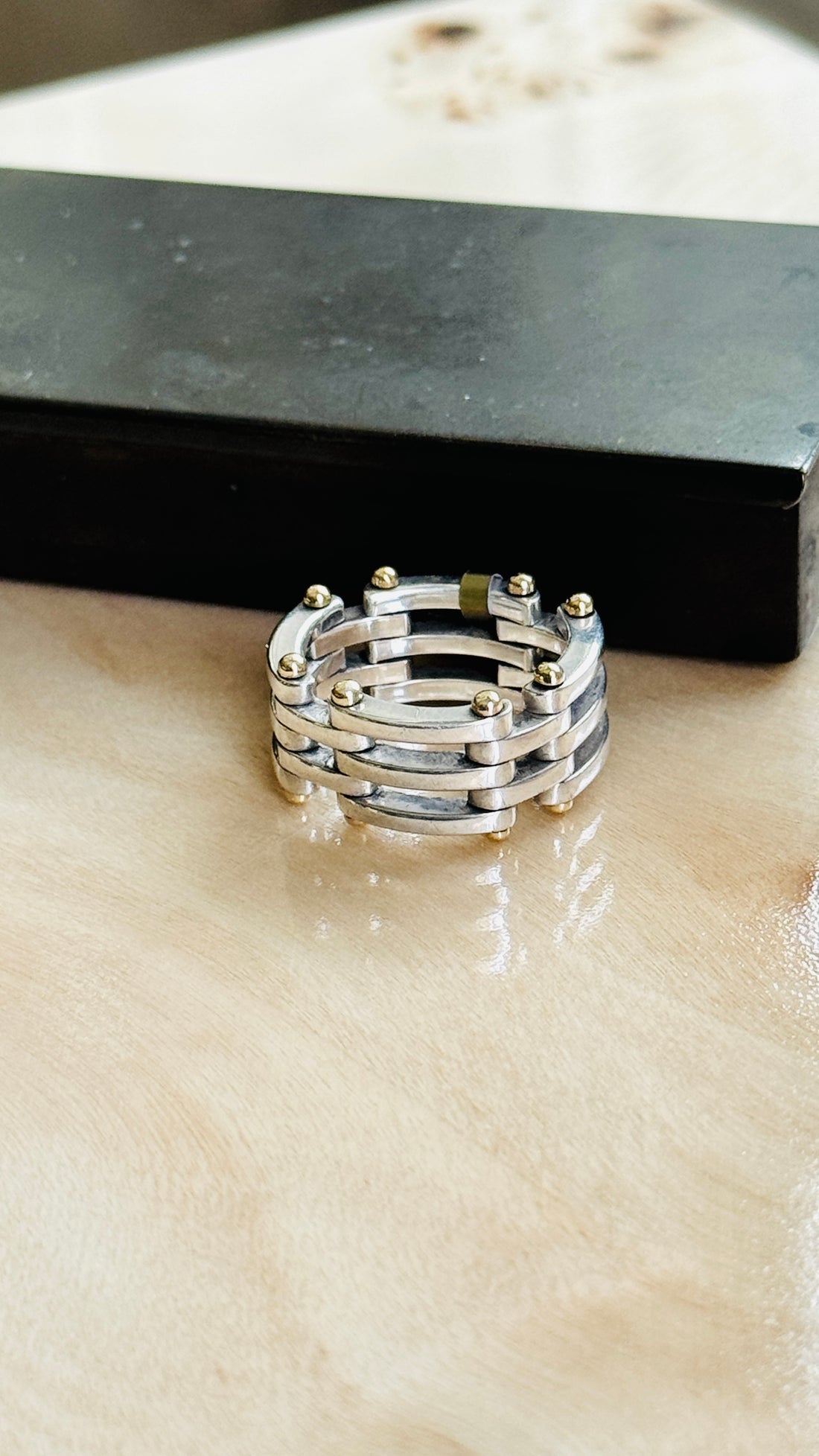 Tiffany & Co. two-tone Gate Link ring on marble beside a dark box
