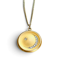 Victorian crescent moon locket shown open, on vintage script paper