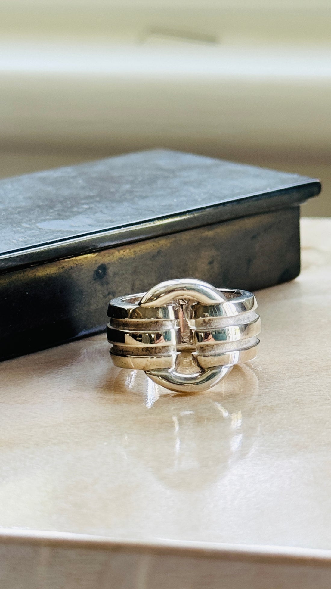 Vintage Tiffany & Co. Atlas ring in sterling silver on a marble surface beside a dark box