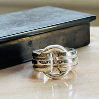 Vintage Tiffany & Co. Atlas ring in sterling silver on a marble surface beside a dark box