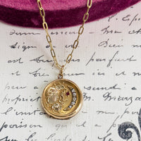 Close-up of vintage moon and starburst locket with paste stones