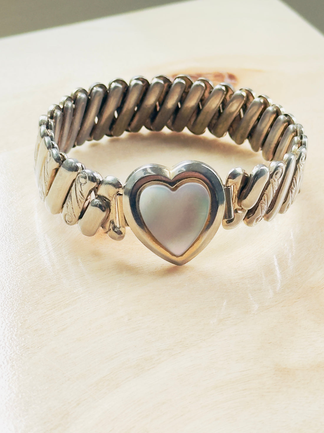 vintage expansion bracelet with mother of pearl heart motif and decorative engraved shoulders,