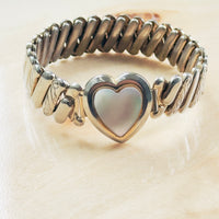 vintage expansion bracelet with mother of pearl heart motif and decorative engraved shoulders,