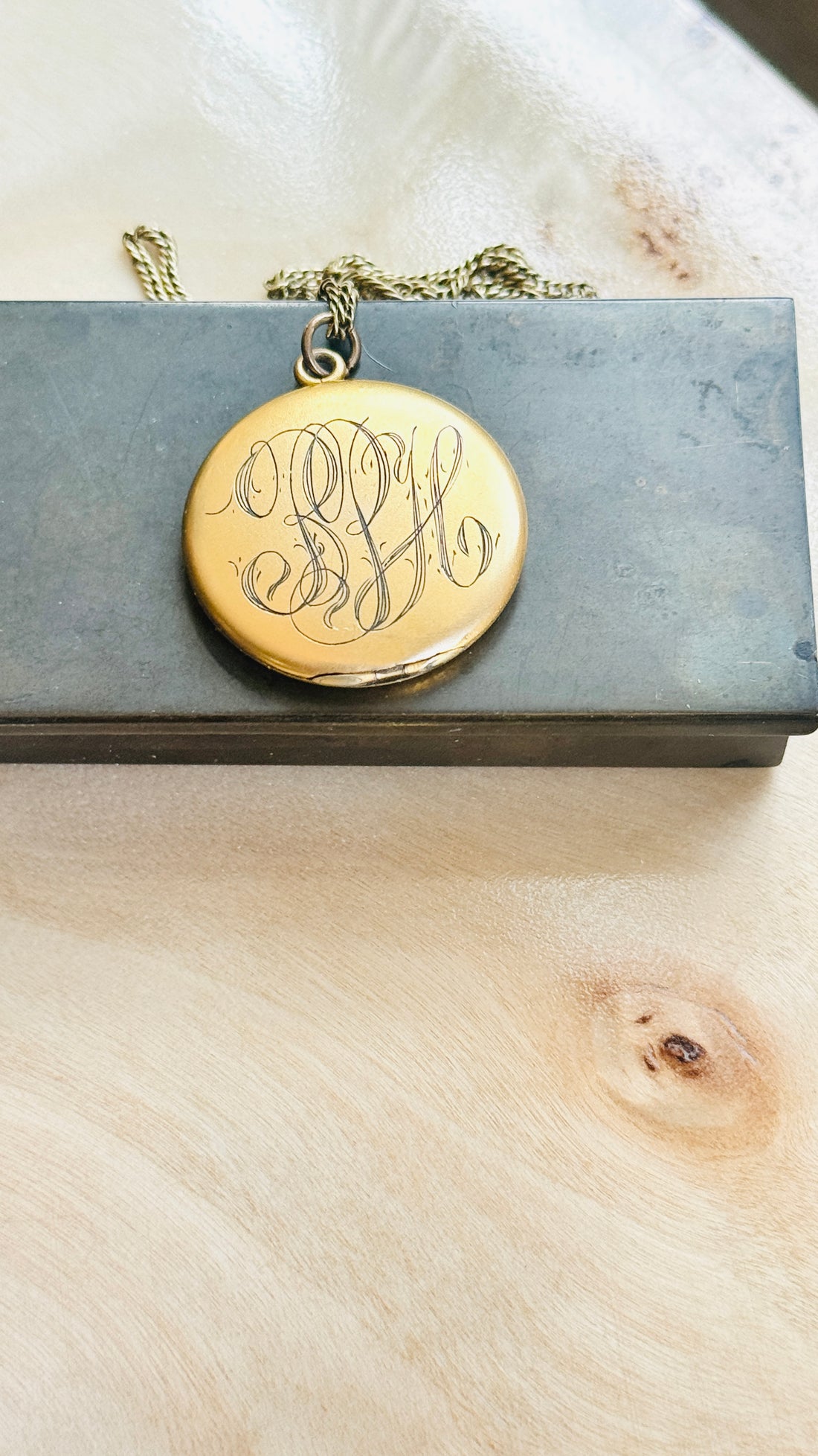 Reverse of the W&H Co. crescent moon locket showing its original hand-engraved monogram