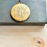 Reverse of the W&H Co. crescent moon locket showing its original hand-engraved monogram